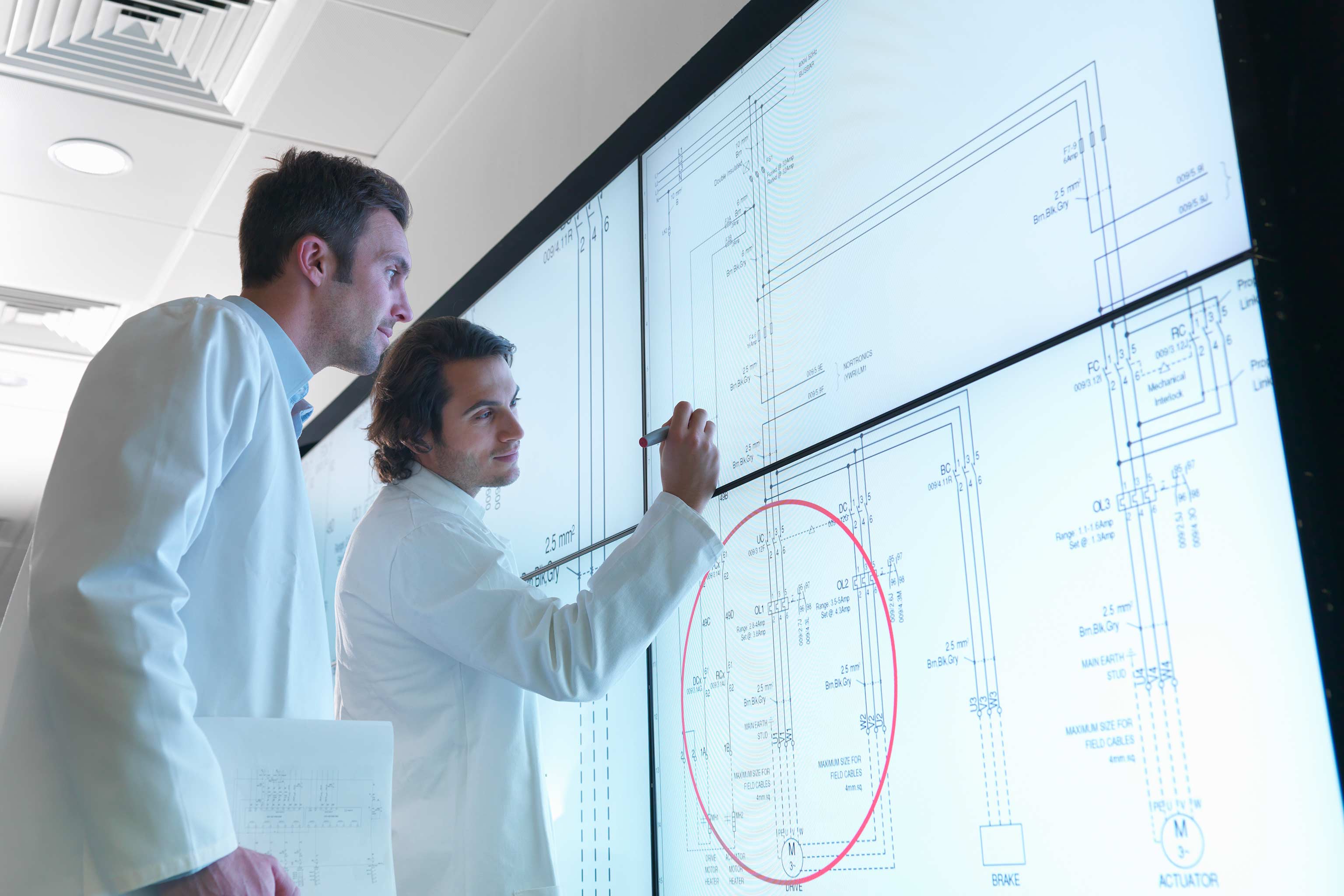 A student and a faculty member in write on the screens in the Visualization Lab in Luddy Hall.